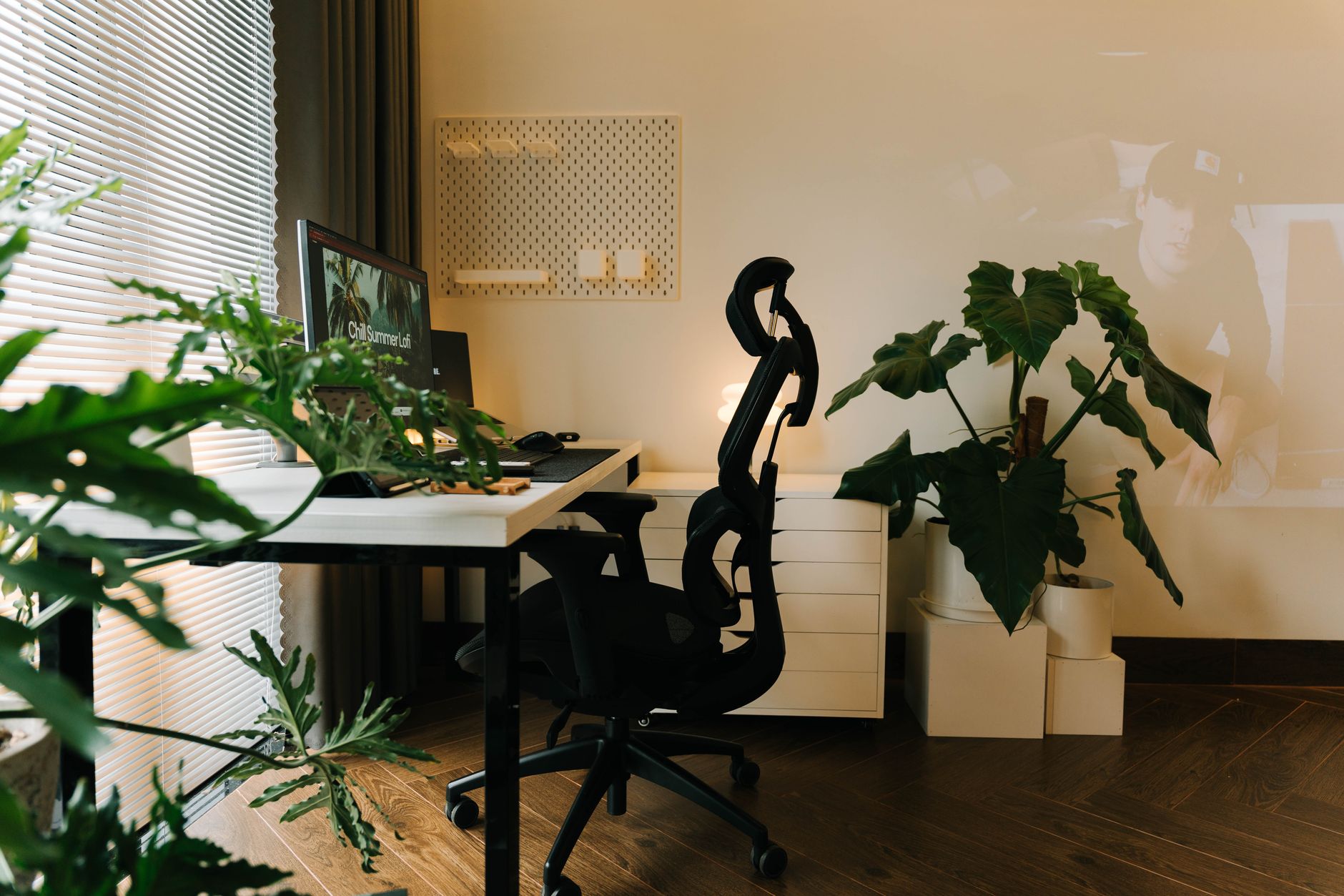 Stylish home office setup with plants and ergonomic chair, perfect for a productive work environment.